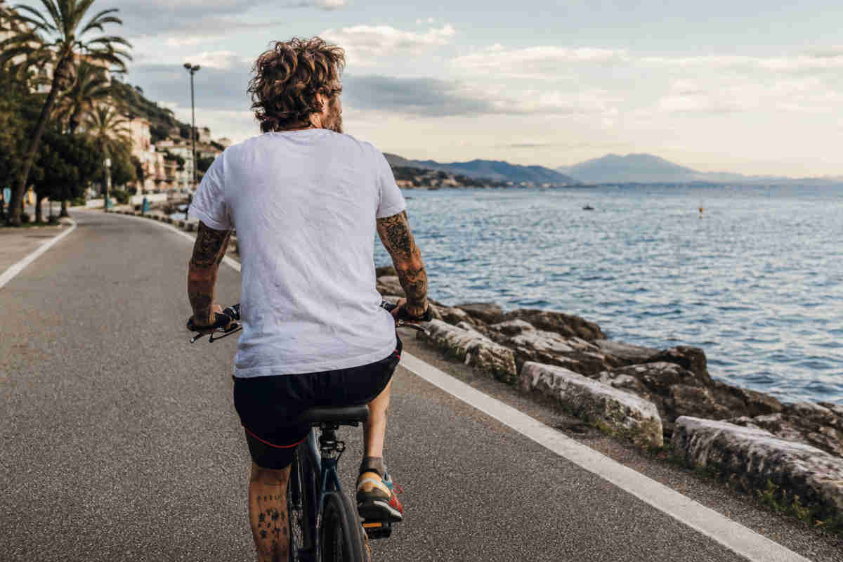 Uomo in bicicletta fotografato di schiena mentre va in bicicletta